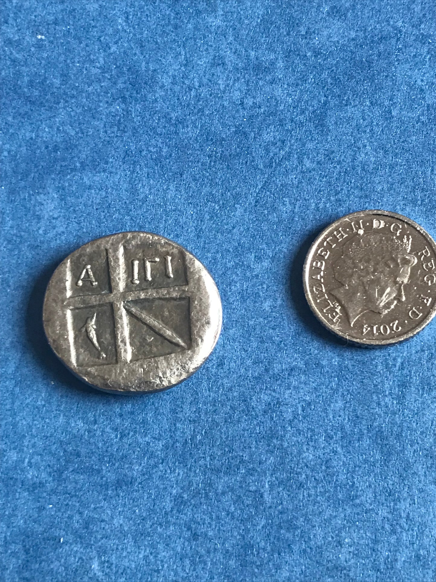 Two silver coins on a blue textured background