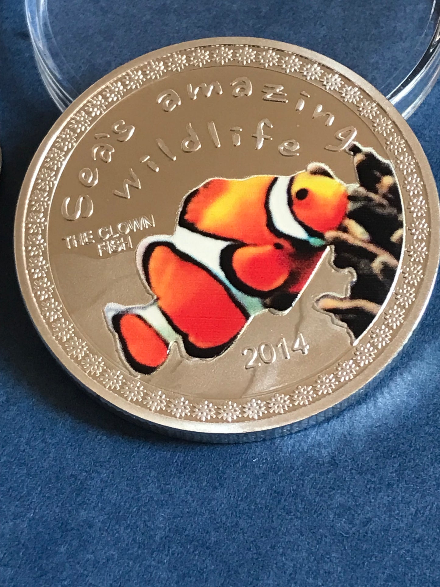 Gold coin with a clownfish design on a blue background