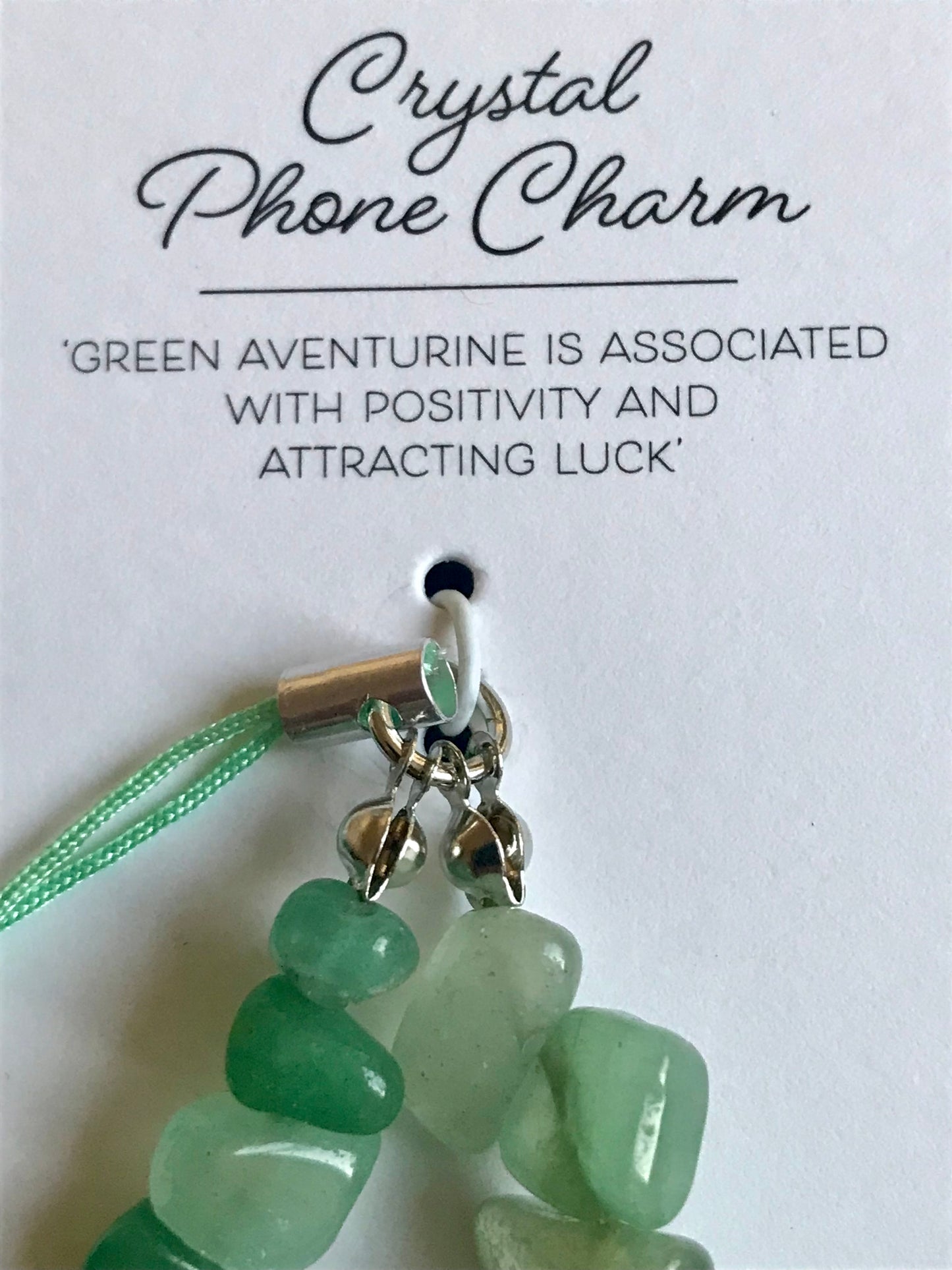 Green crystal phone charm on a white card