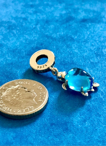 Silver Blue Sea Turtle charm next to a coin on a blue background 925 silver for charm bracelet