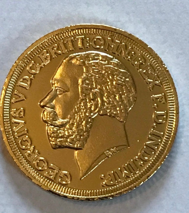 Gold coin with a profile of a monarch on a light gray background