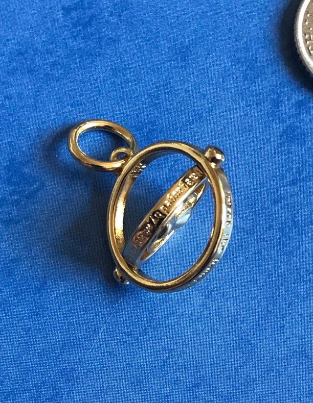 Genuine 925 Silver Time Turner charm with engraved text on a blue background
