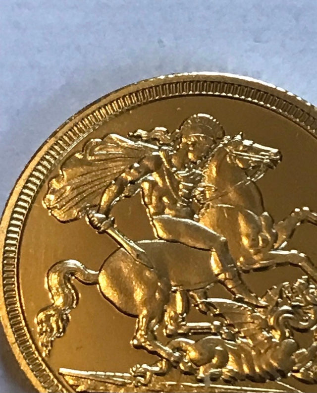 Gold coin with a horse and rider design on a light blue background