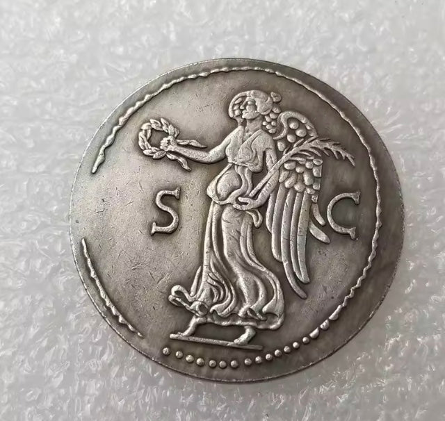 Silver coin with a figure and 'SC' initials on a textured gray background