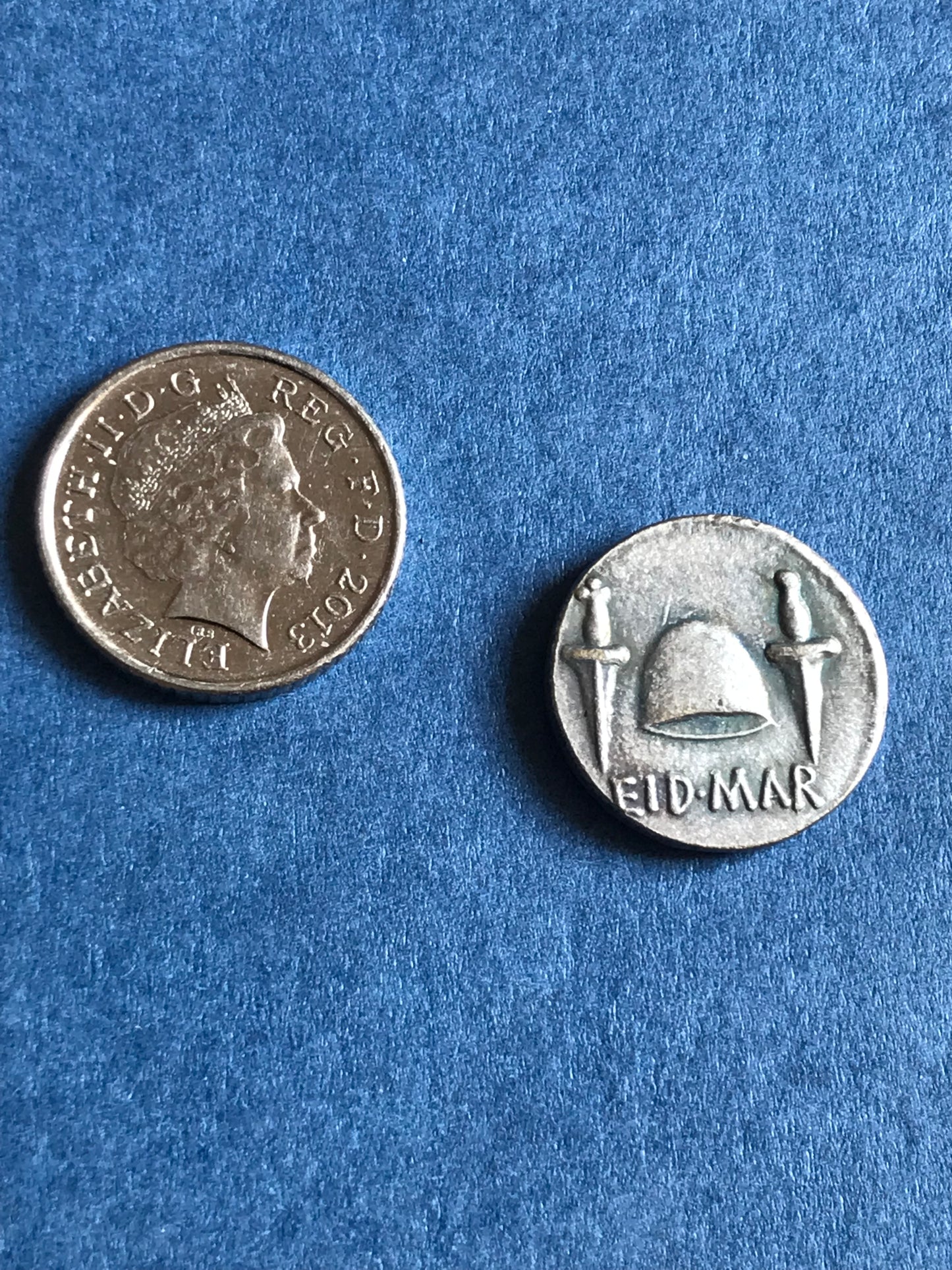 Two silver coins on a blue textured background