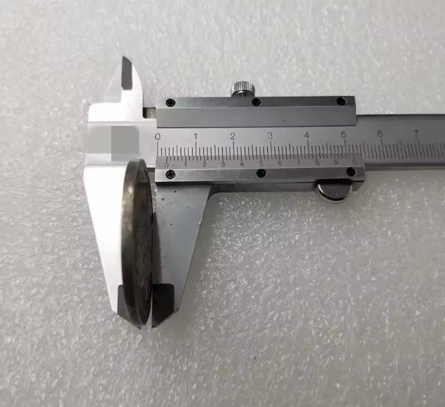 Ancient Roman coin held by metallic vernier caliper on a textured gray background