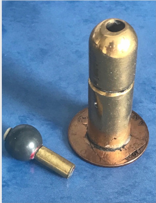 Vintage 1908 dated World War One brass needle holder on a blue background
