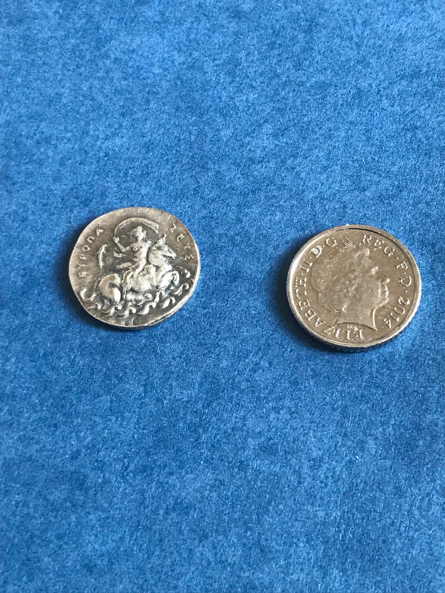 Two silver coins on a blue textured surface