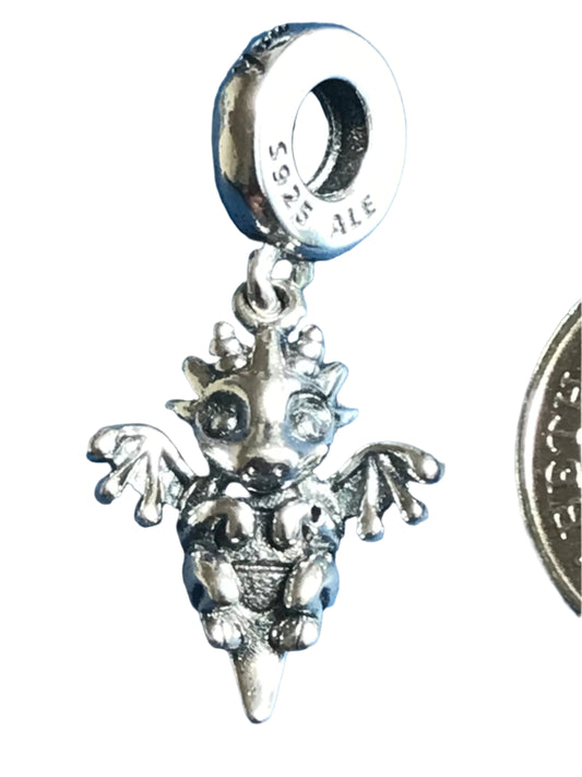 Silver charm with a dragon design on a white background