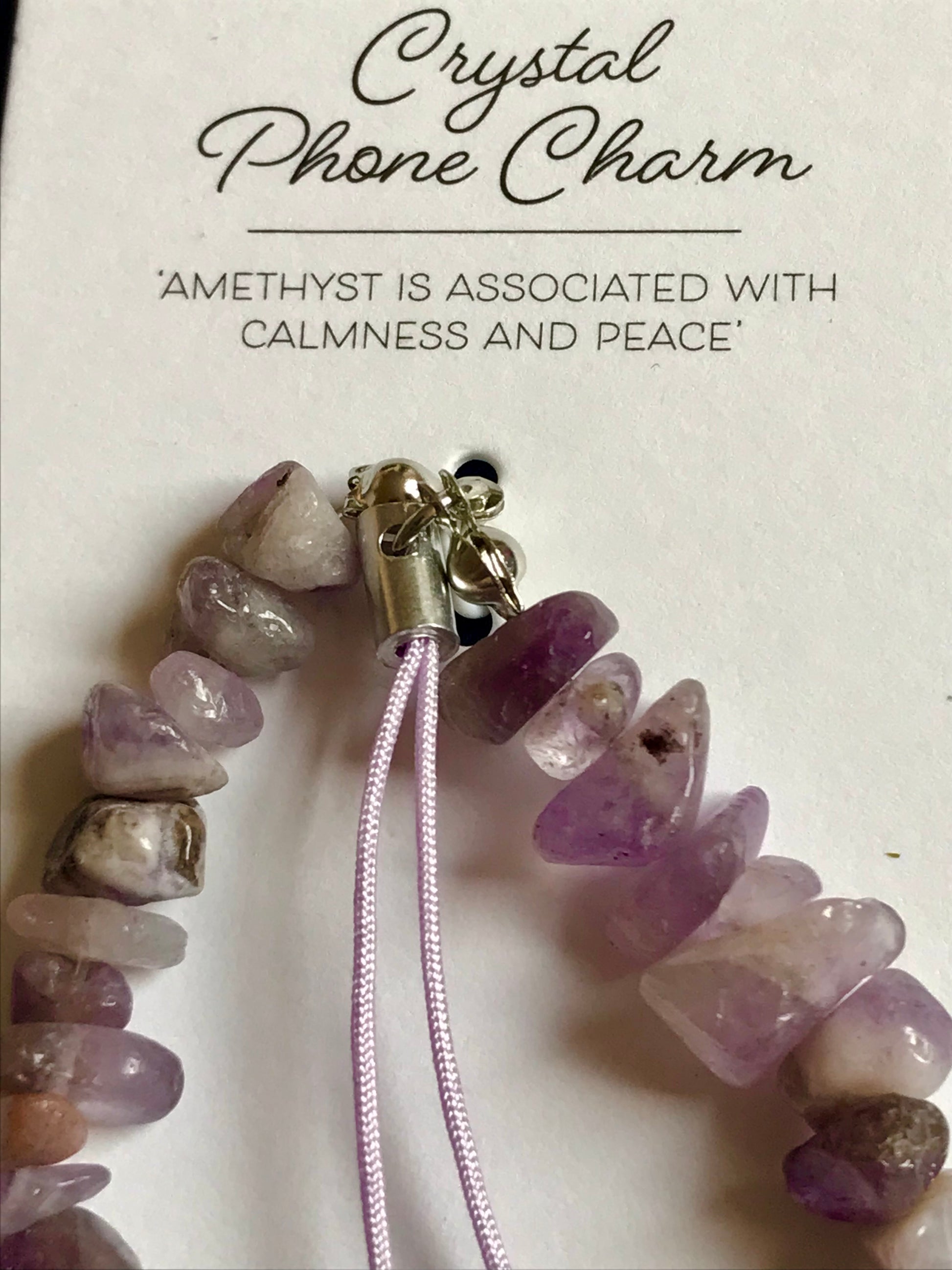 Crystal phone charm with amethyst stones on a white background