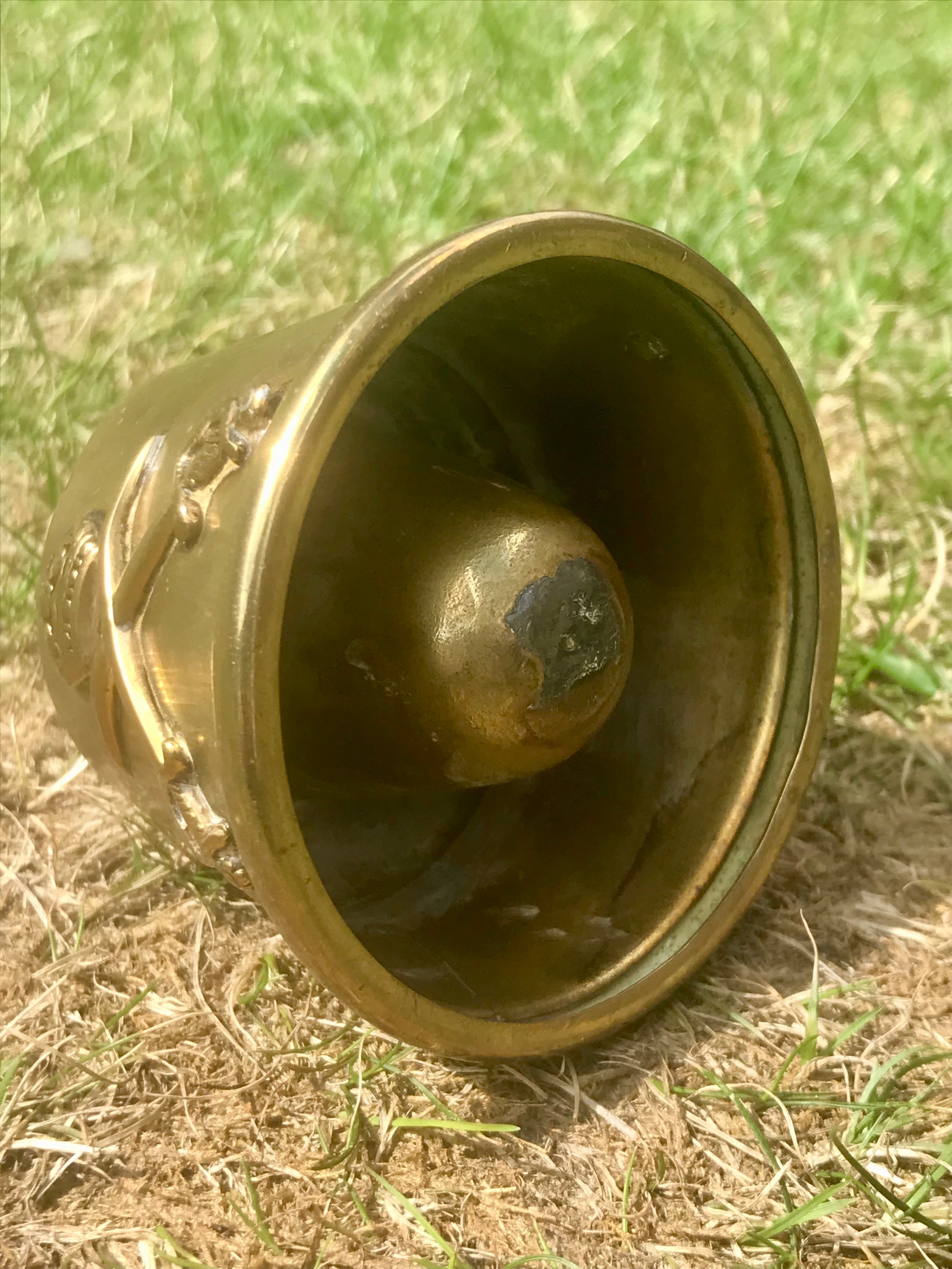 World War Two era Brass fuse cap made into a brass ashtray with cross swords on grass