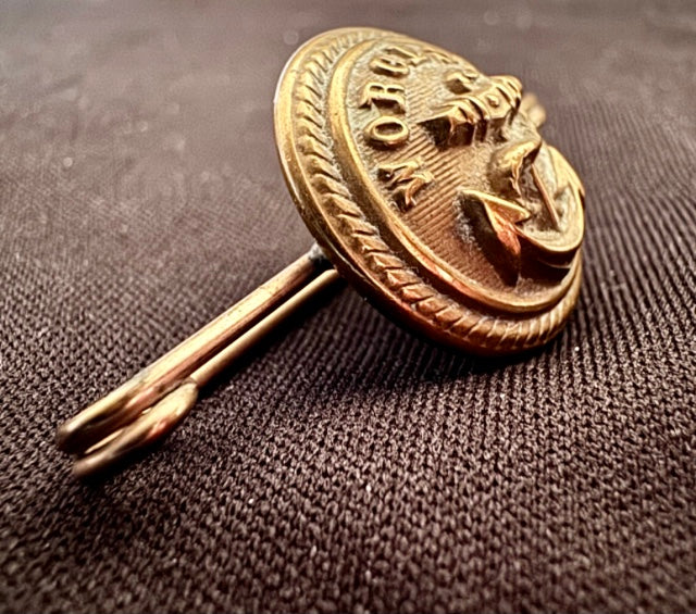 World War Two Trench Art Sweetheart Broach Brass Button on a textured brown background