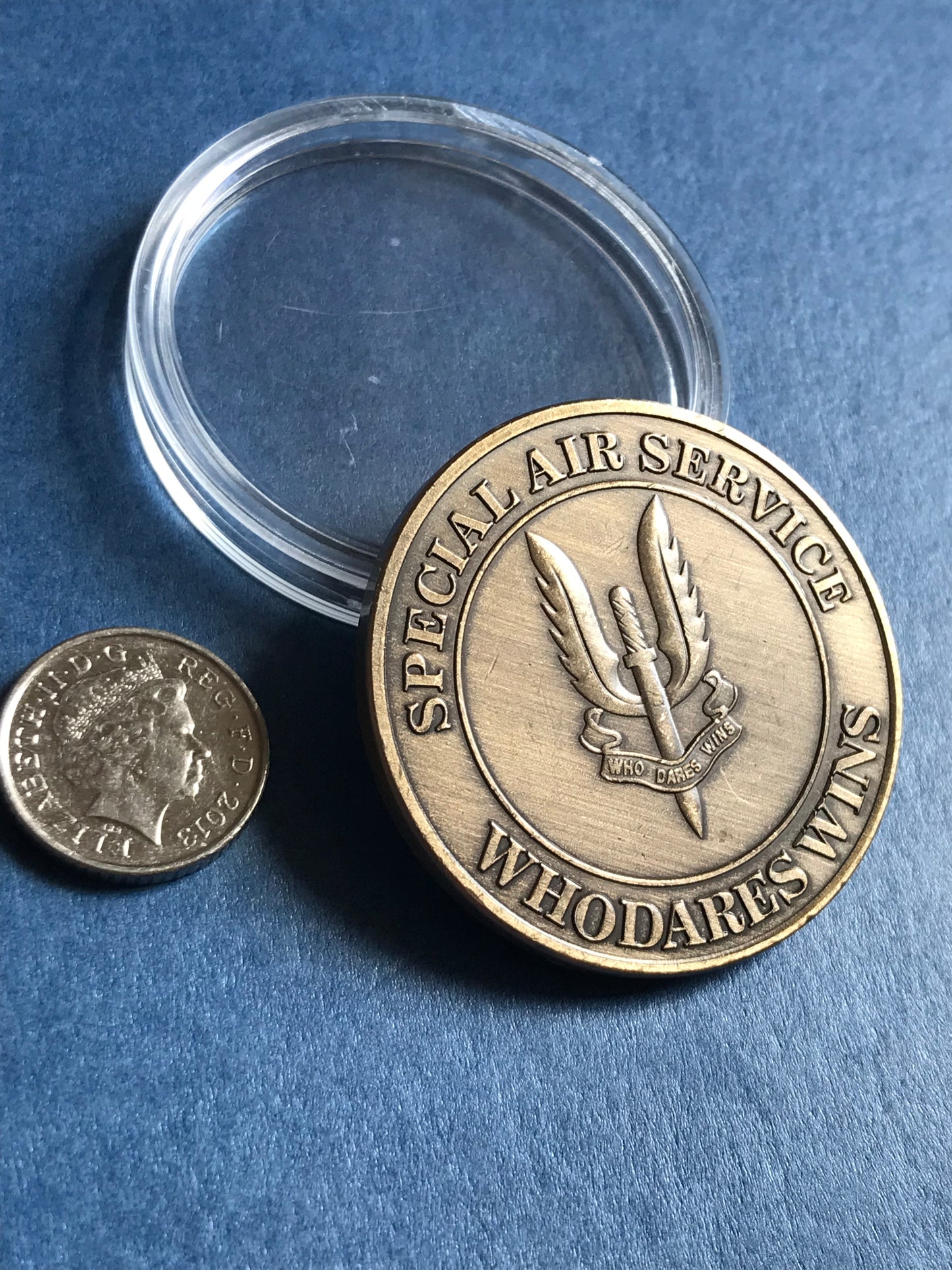 Bronze coin with engraved design on a blue background