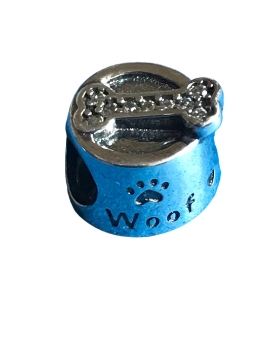 Silver charm with paw prints and 'Woof' text on a blue background
