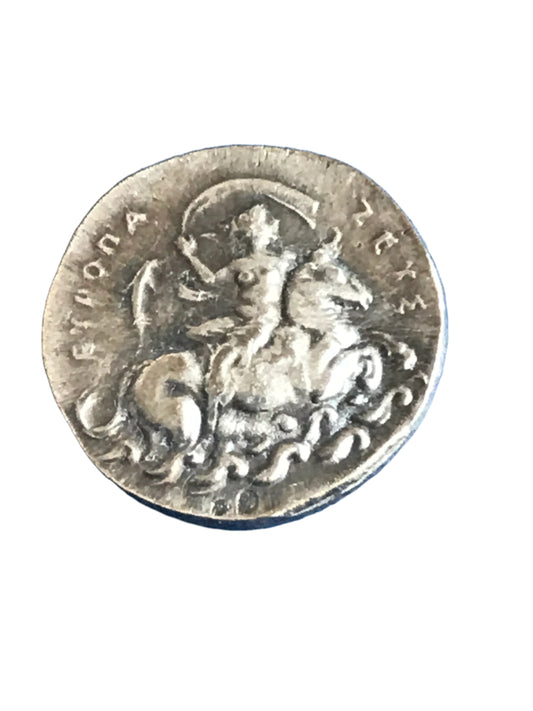 Silver coin with a figure on horseback and text, on a white background