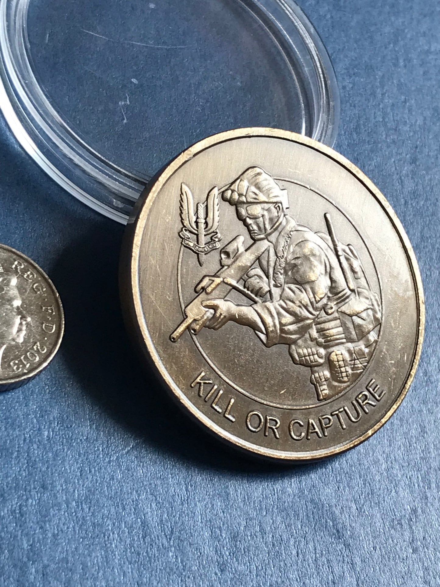 Silver coin with a military design on a blue background