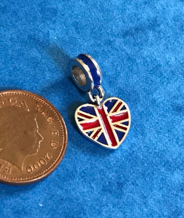Heart-shaped charm with Union Jack design next to a coin on a blue background for charm bracelet 925 silver