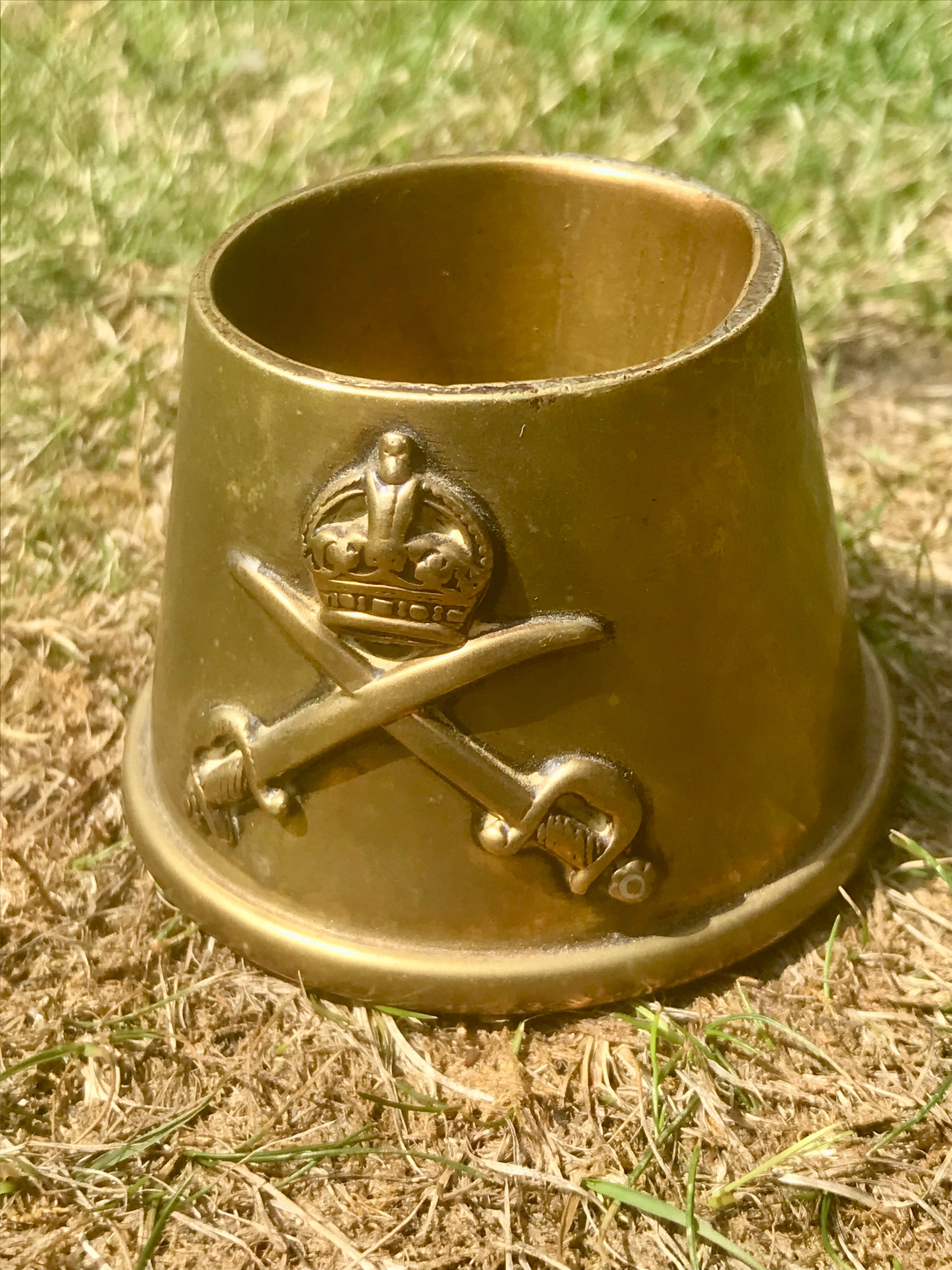 World War Two era Brass fuse cap made into a brass ashtray with cross swords on grass