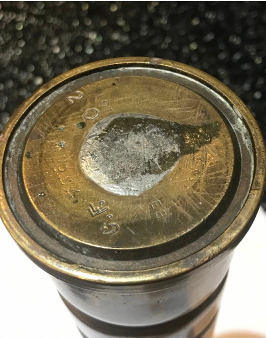 Close-up view of a brass World War Two Trench Art Vase on a kitchen work surface