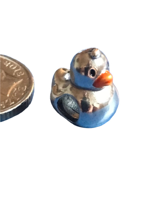 Silver Duck charm next to a coin for scale