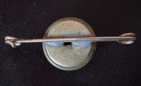 World War Two Trench Art Sweetheart Broach Brass Button on a dark background