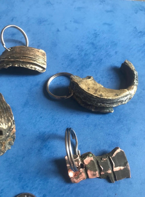 World War Two Battle of Britain Shrapnel key chains on a blue background