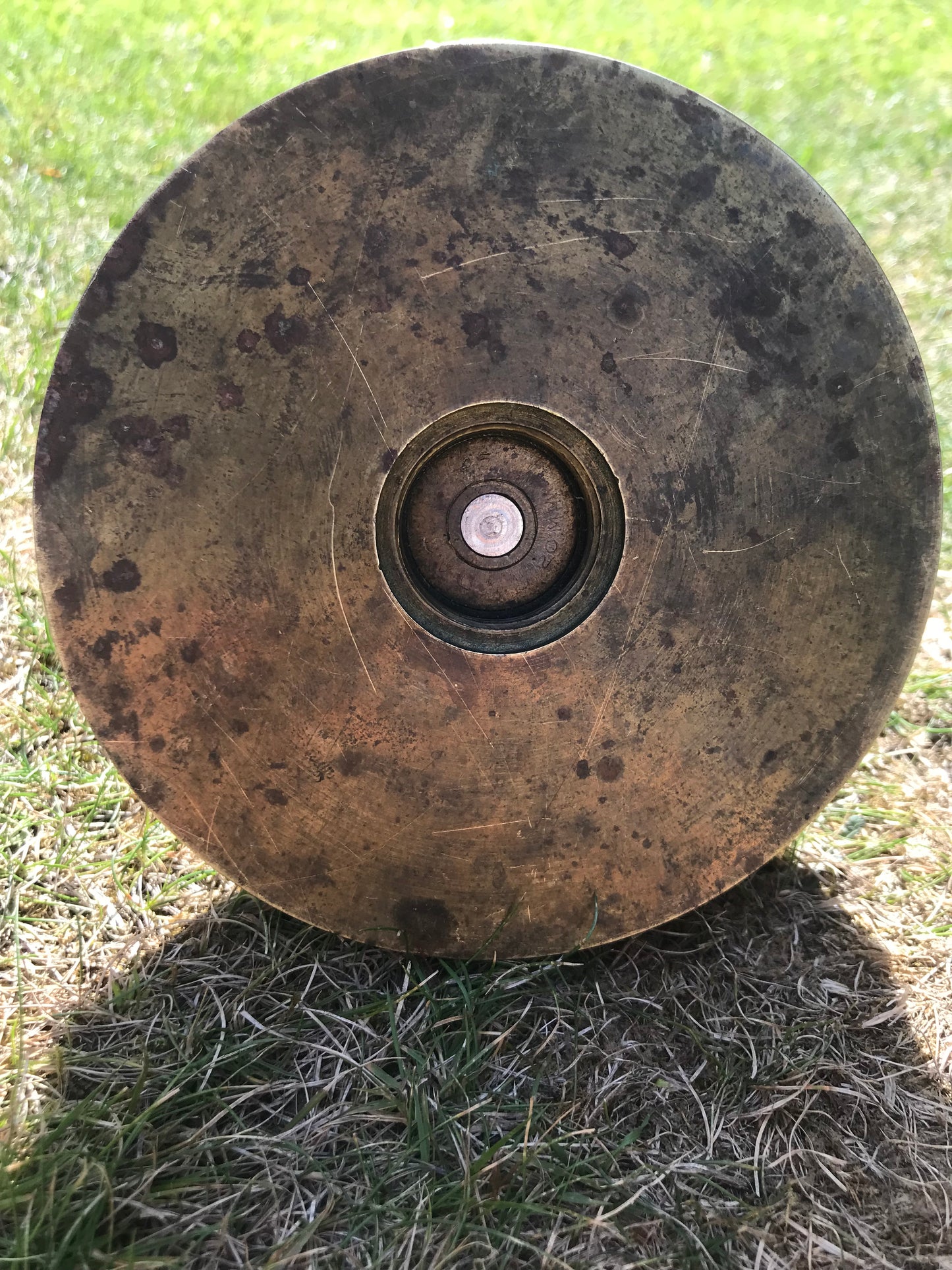 Bottom-view of a 1945 dated trench art brass ashtray on grass