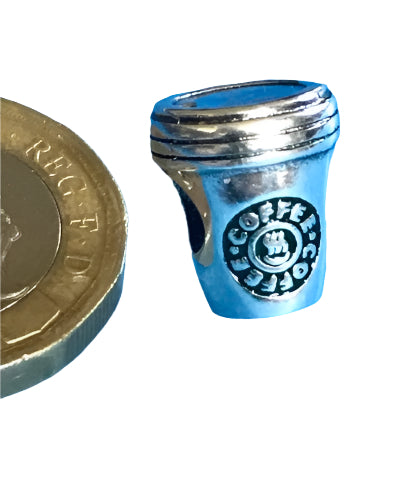Silver Coffee Cup charm next to a British pound coin on a white background