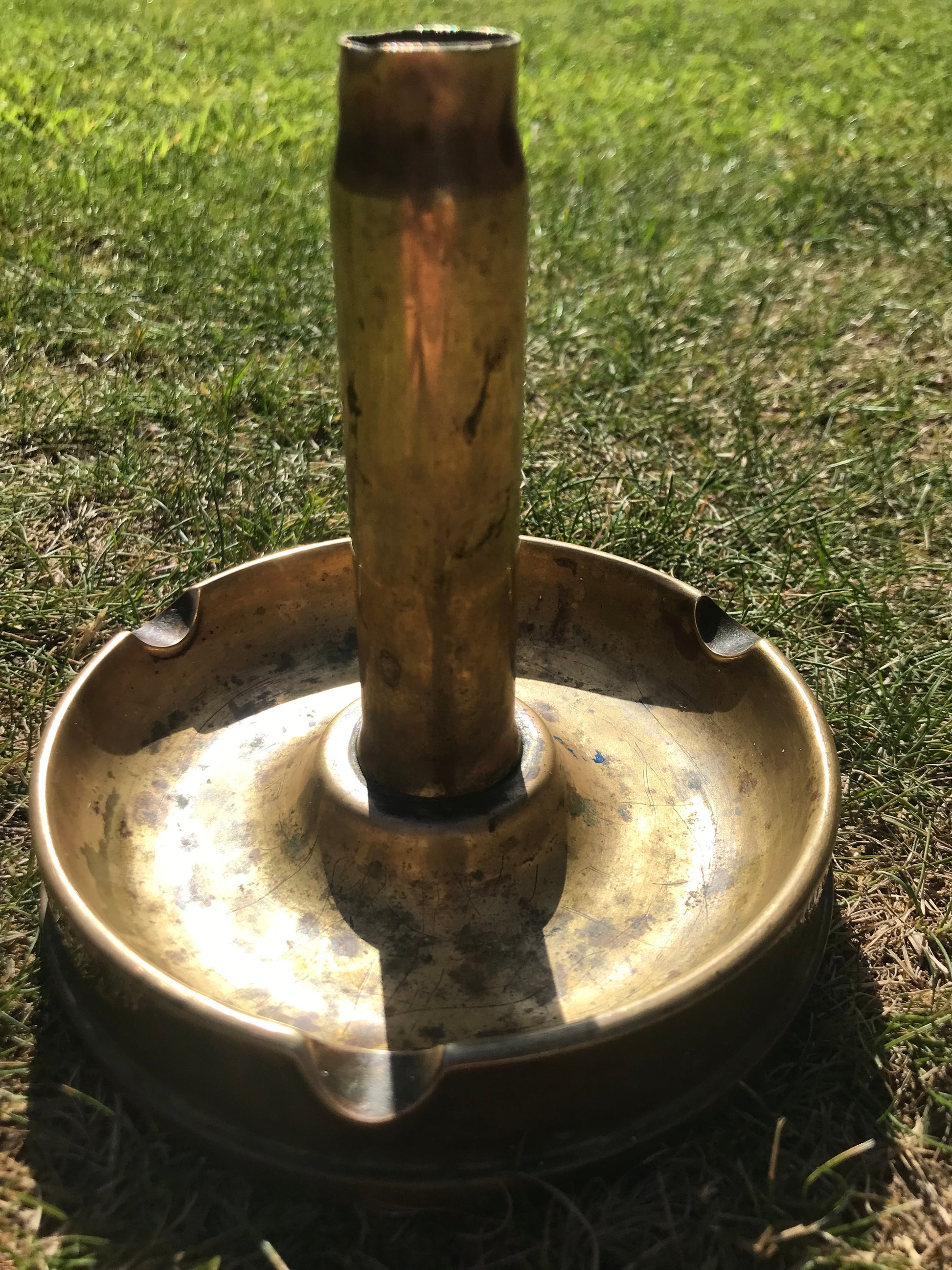 1945 dated trench art brass ashtray on grass
