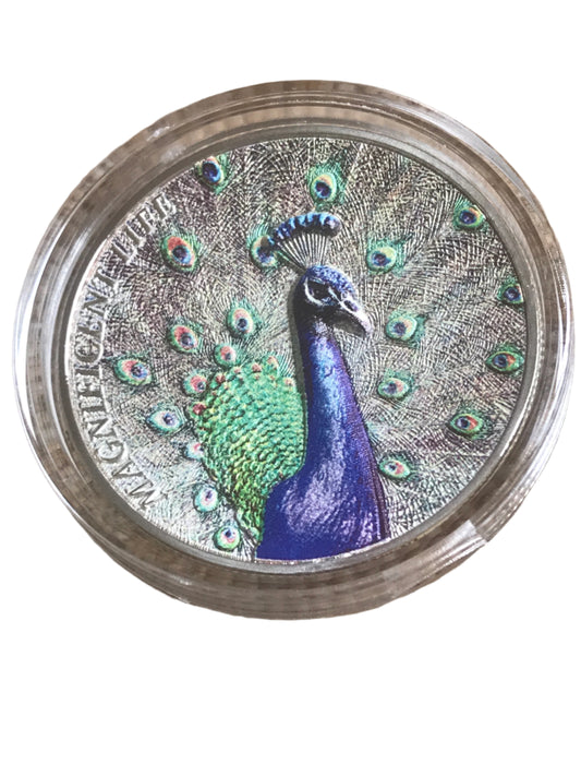 Silver coin with a peacock design on a textured surface
