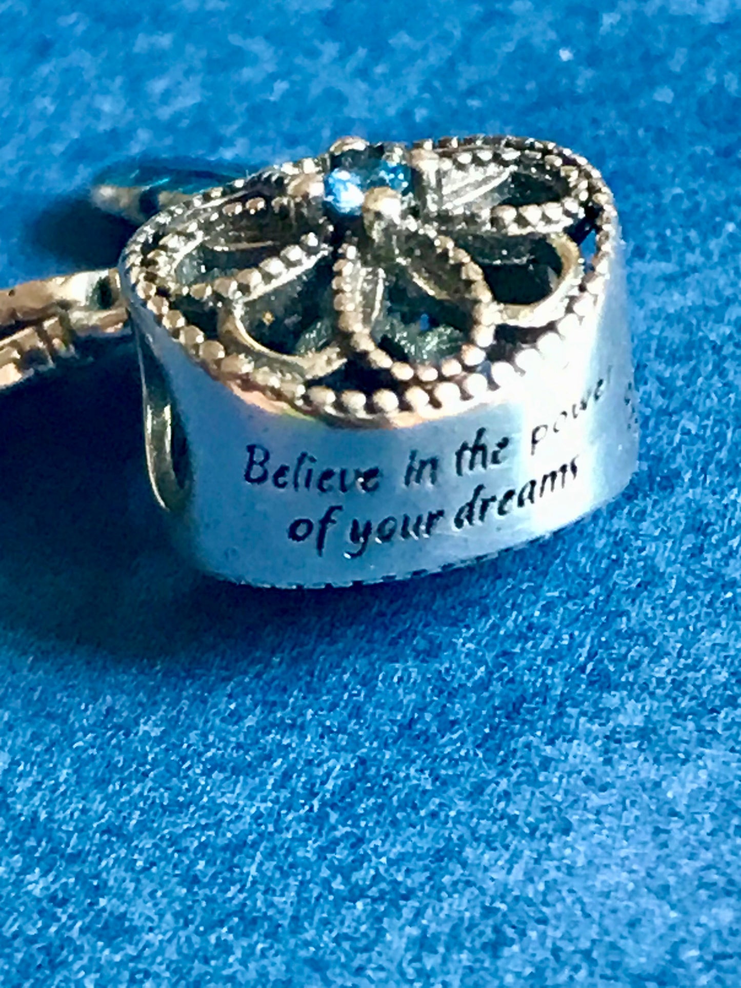 Silver Dreamcatcher Charm with engraved text on a blue background