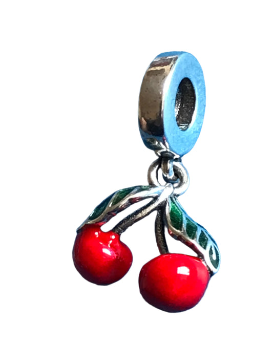 Silver charm with red cherries on a blue background