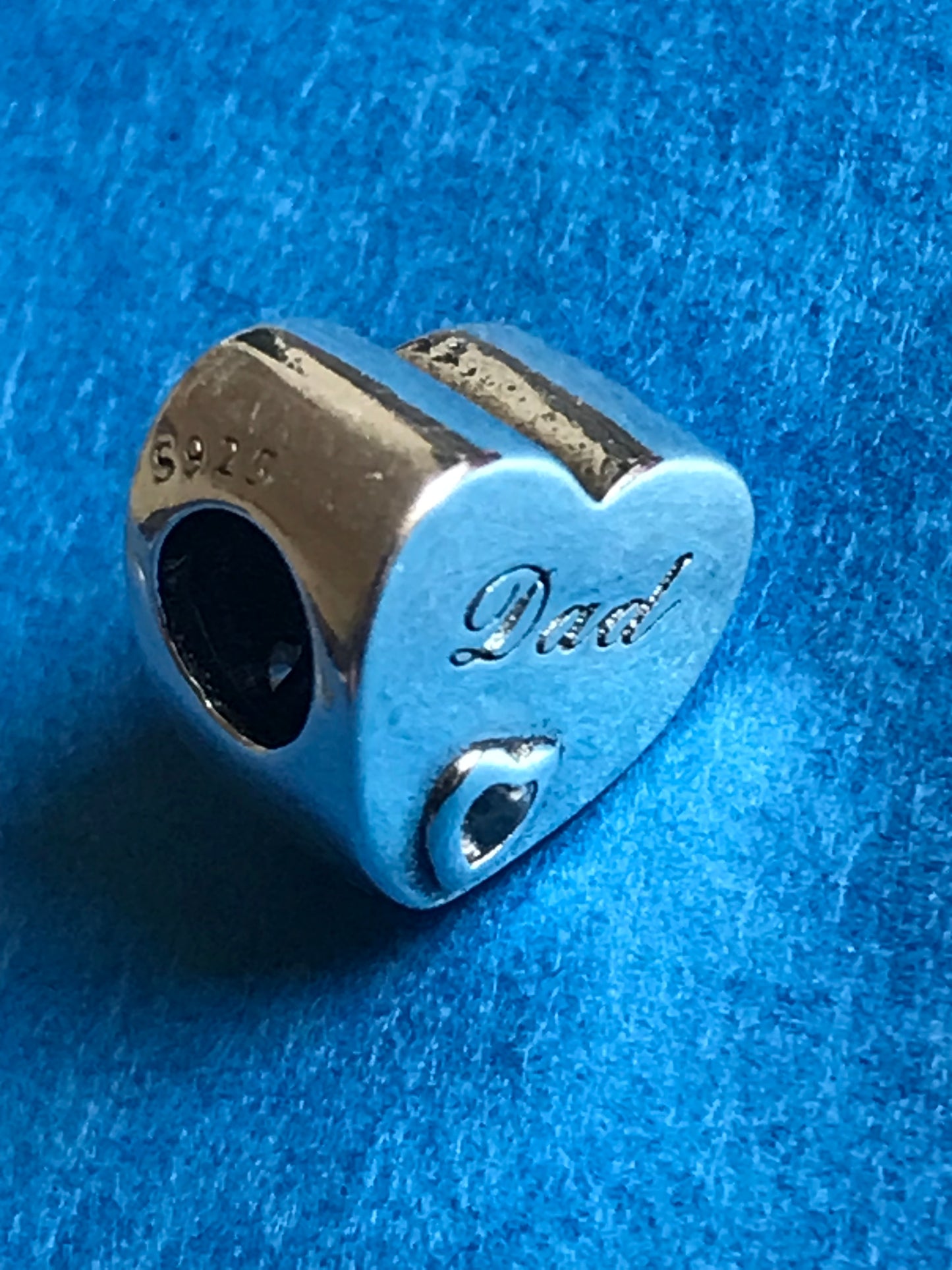 Silver Dad charm on a blue textured background