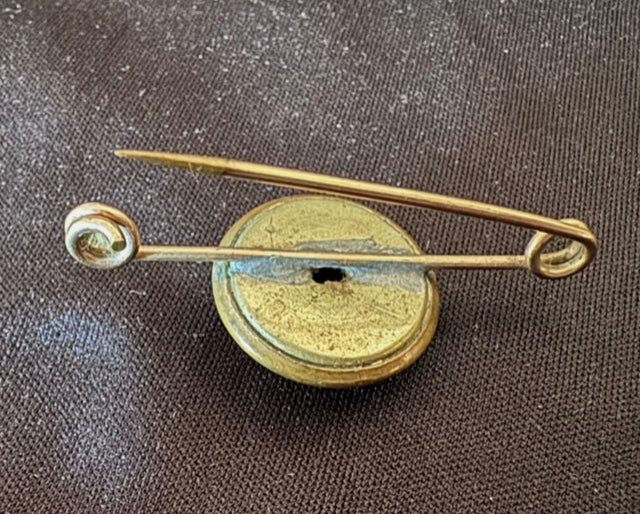 World War Two Trench Art Sweetheart Broach Brass Button on a textured fabric background