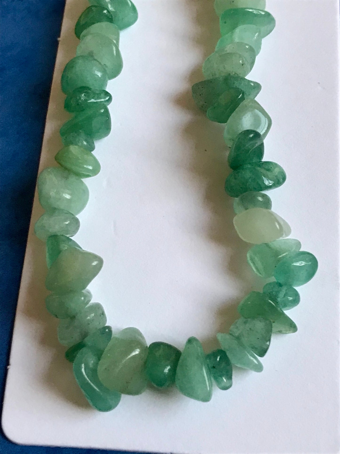 Green crystal phone charm on a white card