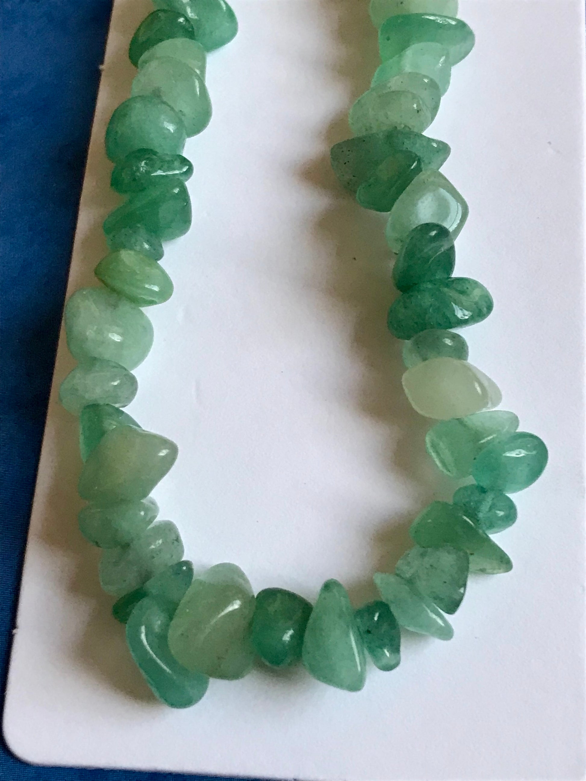 Green crystal phone charm on a white card