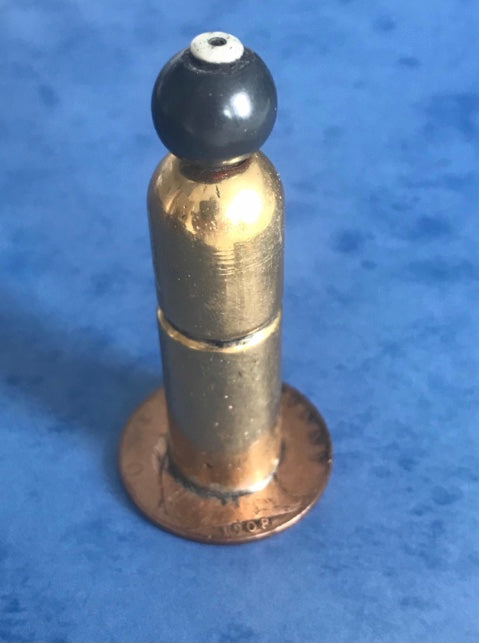 Vintage 1908 dated World War One brass needle holder on a blue background