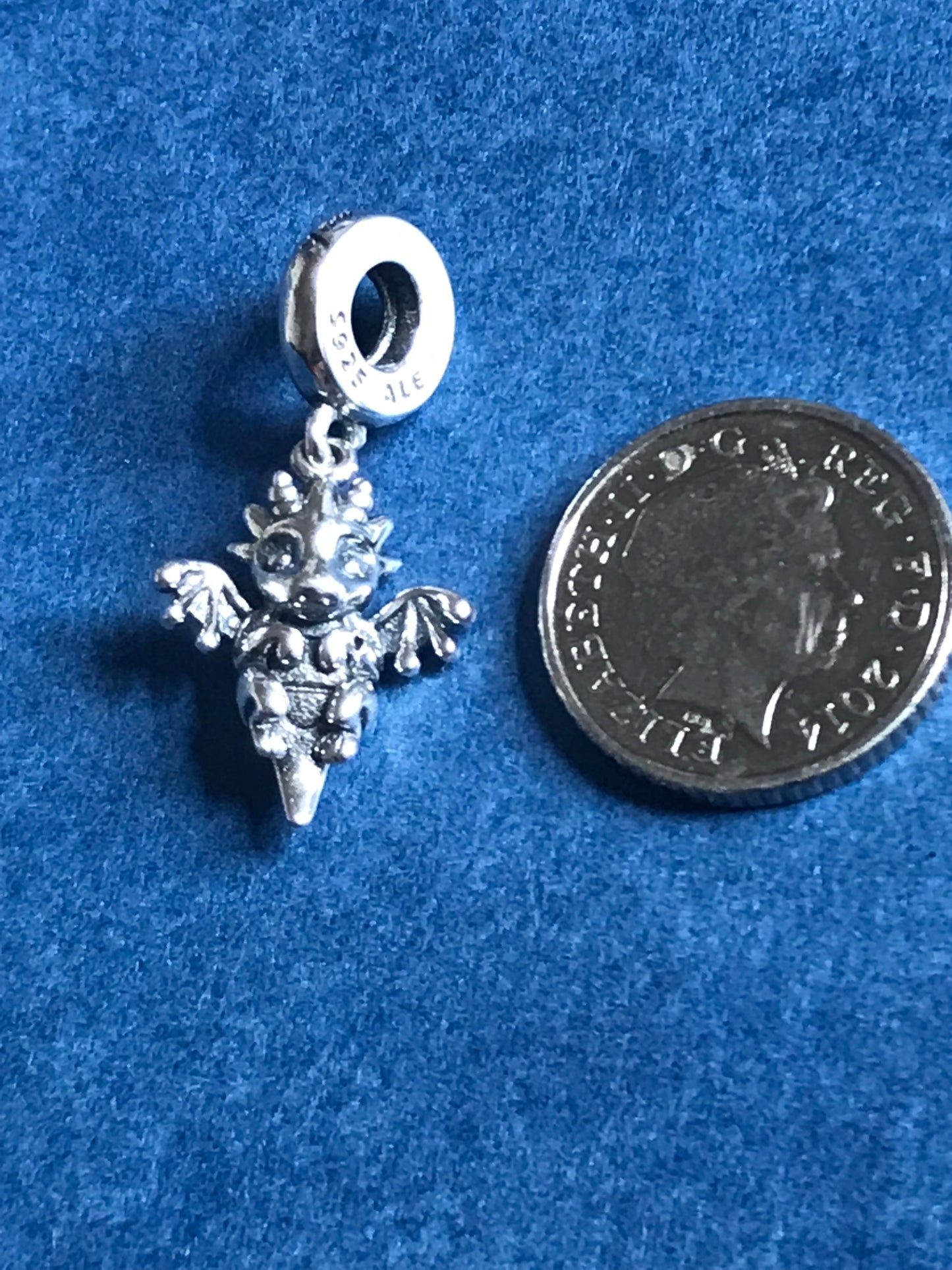Genuine 925 Silver Dragon charm next to a coin on a blue background for charm bracelet 