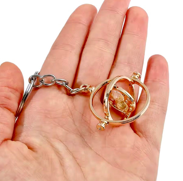 Harry Potter Time Turner Keyring gold colour held in a hand against a white background