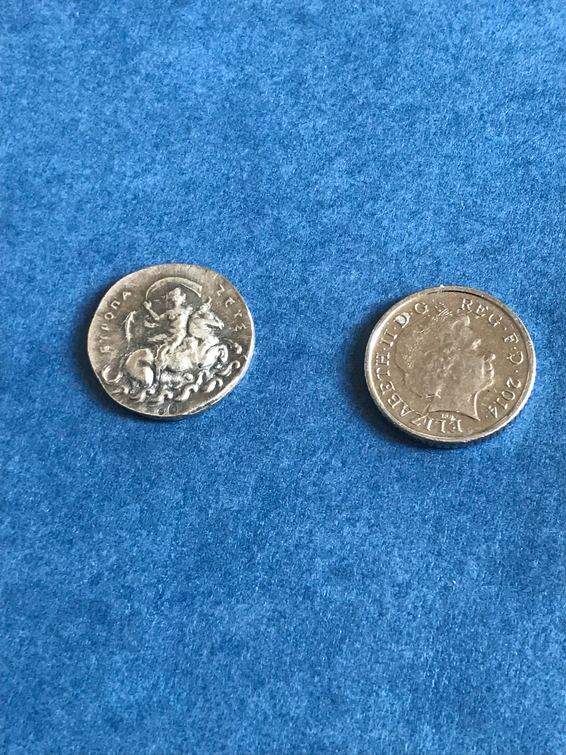 Two silver coins on a blue textured surface